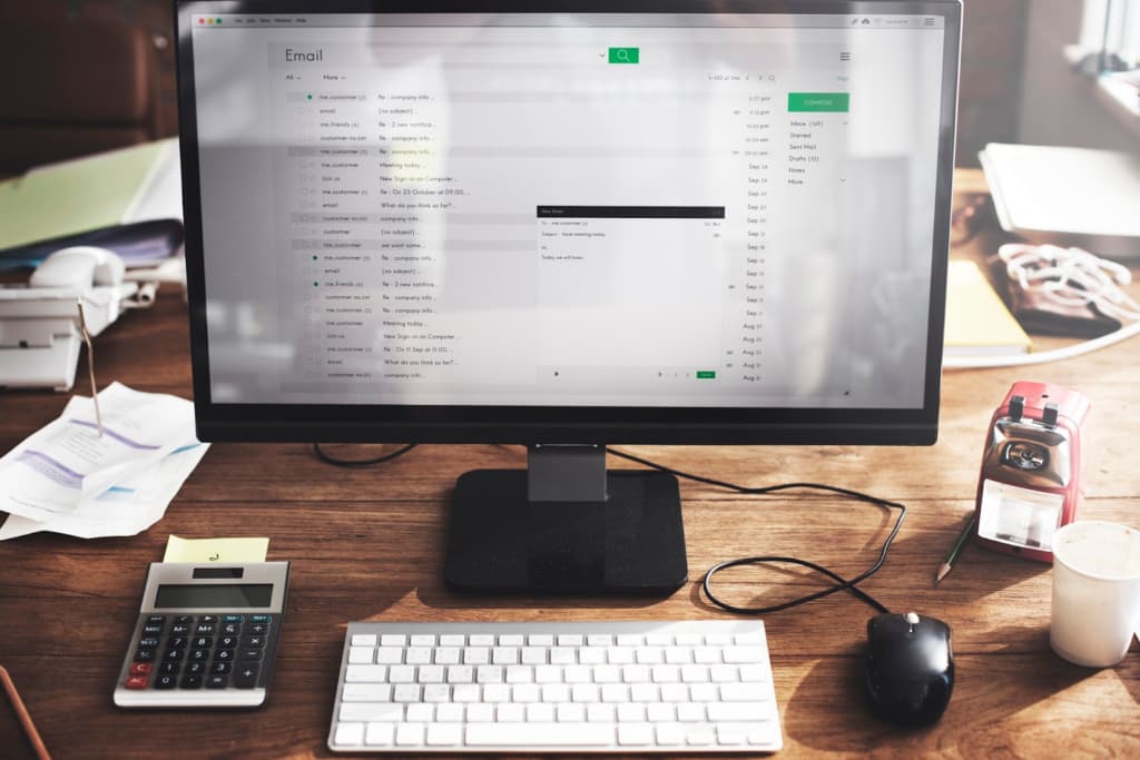 Computer with email on desk in office